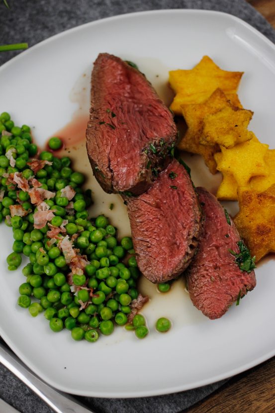 Gekräutertes Rinderfilet mit Polenta Sternen und Speckerbsen