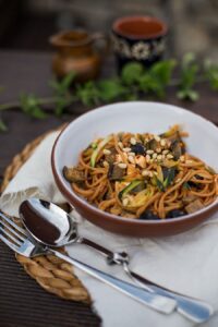 Zucchini Zoodles Rezept mit Aubergine, Oliven und Pinienkernen