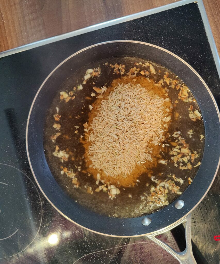 Hähnchen Pfanne mit Reis - Einfaches One Pan Rezept 9 Step 4 - Brühe & Reis dazu